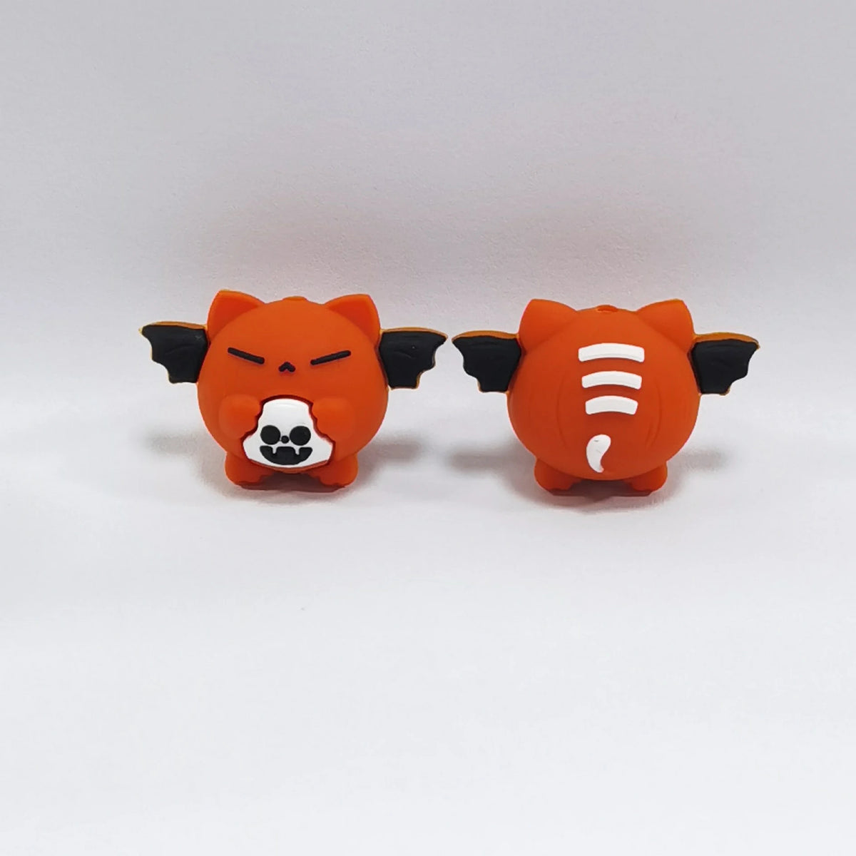 Winged Pumpkin - Orange Halloween silicone focal bead design on a pale background